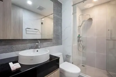 a bathroom with a sink and a toilet and a shower at Aquila Hotel Bangkok in Bangkok