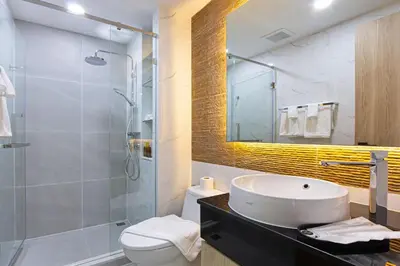 a bathroom with a sink and a toilet and a shower at Aquila Hotel Bangkok in Bangkok
