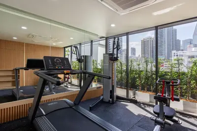 a gym with a view of a city skyline at Aquila Hotel Bangkok in Bangkok