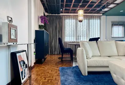 a living room with a white couch and a table at Brown Brick Thonglor - Green Greenery Room in Bangkok