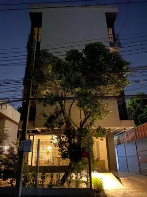 a tree in front of a building at night at THE CELESTRAIL - Apartment - Check-In by Appointment Only - Non-hotel - Onnut BTS in Bangkok