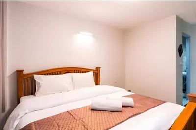 a bedroom with a large bed with white sheets at XX GO INN Khaosan The Grand Palace Bangkok in Bangkok