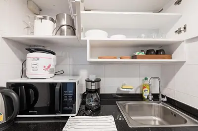 a kitchen counter with a microwave and a sink at Artichoke Suite Sukhumvit, Nana BTS in Bangkok