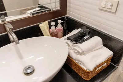 a bathroom with a white sink and a mirror at Artichoke Suite Sukhumvit, Nana BTS in Bangkok