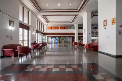 an empty lobby with red chairs and tables in a building at Artichoke Suite Sukhumvit, Nana BTS in Bangkok