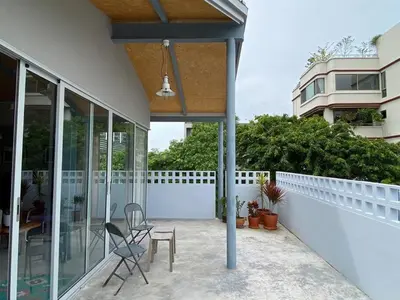 a patio with two chairs and a table on a house at Private apartment at Sukhumvit67 Penthouse Unit in Bangkok