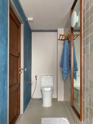 a small bathroom with a toilet and a door at Private apartment at Sukhumvit67 Penthouse Unit in Bangkok