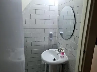 a white bathroom with a sink and a mirror at Haus Sathorn Pier 2 Cozy Bedroom City Center in Bangkok