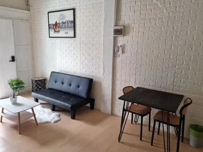 a living room with a couch and a table at Haus Sathorn Pier 2 Cozy Bedroom City Center in Bangkok
