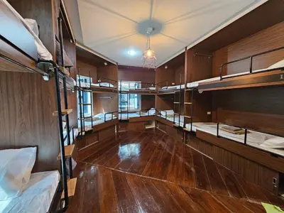 an empty room with bunk beds and wooden walls at Seen Hostel Bangkok The Riverwalk in Bangkok