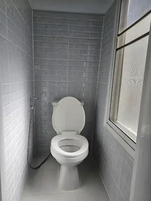 a small bathroom with a toilet and a window at Seen Hostel Bangkok The Riverwalk in Bangkok