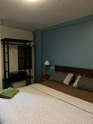 a bedroom with two beds and a blue wall at Blue Chang House in Bangkok