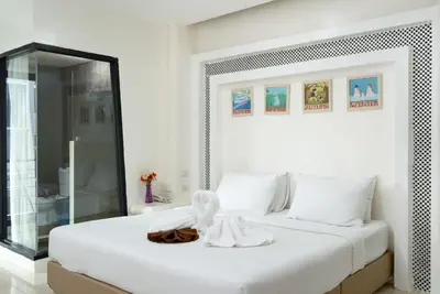 a white bedroom with a large white bed at Baron Zotel Bangkok SHA PLUS in Bangkok