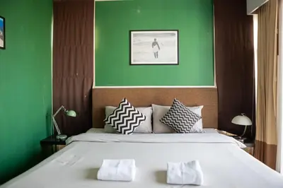 a bedroom with a large bed with green walls at P Villa Lamoon Thonglor in Bangkok