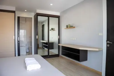 a bedroom with a white bed and a mirror at P Villa Lamoon Thonglor in Bangkok