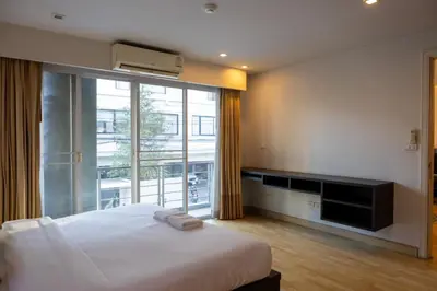 a bedroom with a large bed and a large window at P Villa Lamoon Thonglor in Bangkok