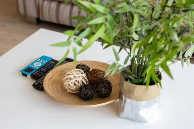 a wooden bowl of balls on a table next to a plant at P Villa Lamoon Thonglor in Bangkok
