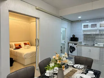 a room with a bed and a table with flowers on it at MIQ HK256 5BR MRT Ratchada and HuaiKhwang in Bangkok