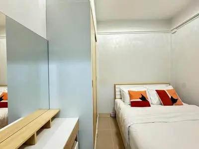 a small bedroom with a bed and a wooden bench at MIQ HK256 5BR MRT Ratchada and HuaiKhwang in Bangkok