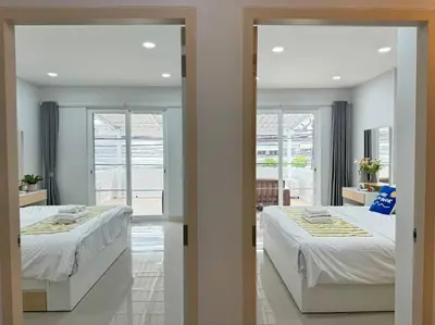 two beds in a room with two windows at MIQ HK256 5BR MRT Ratchada and HuaiKhwang in Bangkok