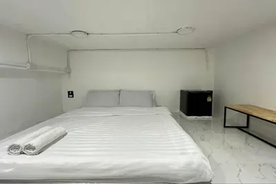 a white bed with two towels on it in a room at Megun capsule 150 cm in Bang O
