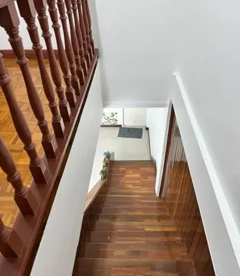 a staircase in a home with wooden floors and white walls at MIQ HK611 Huai Khwang 4BR Jodd fair in Bangkok