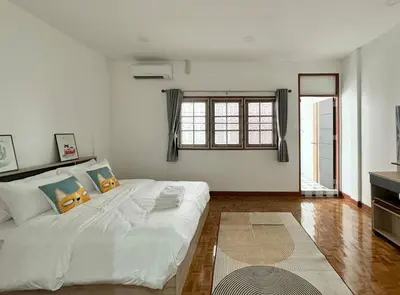 a white bedroom with a large bed and a window at MIQ HK611 Huai Khwang 4BR Jodd fair in Bangkok