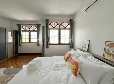 a large white bed in a room with two windows at MIQ HK611 Huai Khwang 4BR Jodd fair in Bangkok