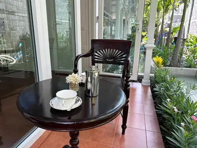 a black table with a cup and aucer on a porch at Baan Debtida in Bangkok