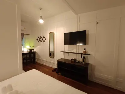 a bedroom with a bed and a tv on the wall at Baan Debtida in Bangkok