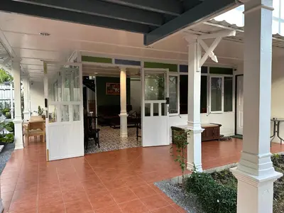an open porch of a house with white columns at Baan Debtida in Bangkok