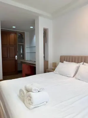 a bedroom with a white bed with towels on it at Miq Asoke 5BR Sukhuvit15 in Makkasan