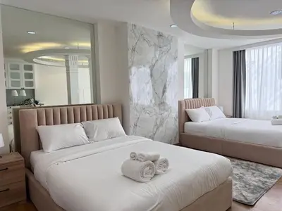 a bedroom with two beds with towels on them at Miq Asoke 5BR Sukhuvit15 in Makkasan