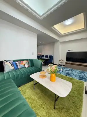 a living room with a green couch and a table at Miq Asoke 5BR Sukhuvit15 in Makkasan