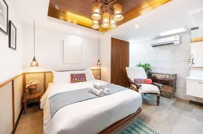 a bedroom with a large white bed and a chair at MIQ Rama9 Villa 3Br in City Jodd fair MRT in Makkasan