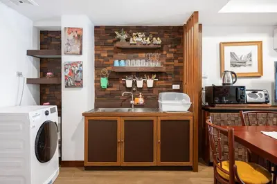 a kitchen with a sink and a counter with a washing machine at MIQ Rama9 Villa 3Br in City Jodd fair MRT in Makkasan
