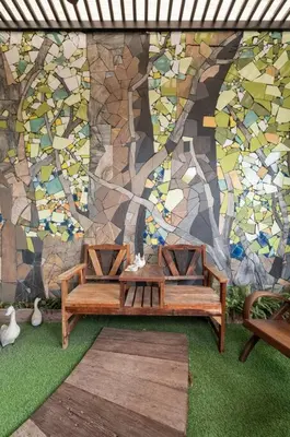 a table and two chairs in front of a mosaic wall at MIQ Rama9 Villa 3Br in City Jodd fair MRT in Makkasan