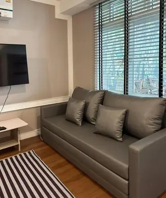 a living room with a couch and a flat screen tv at MIQ Rama9 Villa 3Br in City Jodd fair MRT in Makkasan