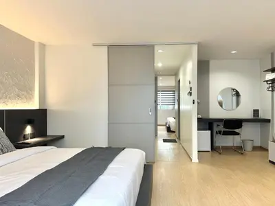 a bedroom with a bed and a desk at Lune bangkok in Bangna