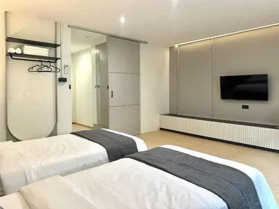 two beds in a room with a flat screen tv at Lune bangkok in Bangna