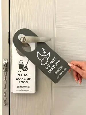 a persons hand holding a door tag on a door at Lune bangkok in Bangna