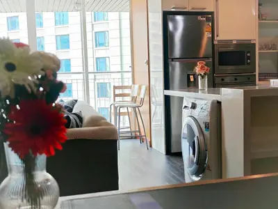 a kitchen with a refrigerator and a vase of flowers at City comfort appartment, Skytain Step 600 m, Erawan shrine in Bang Kapi