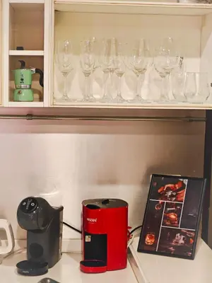 a kitchen counter with wine glasses on a shelf at City comfort appartment, Skytain Step 600 m, Erawan shrine in Bang Kapi