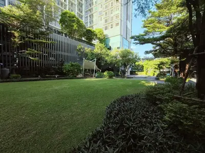 a park with a chair sitting in the grass at Close to onnut bts condo in Bangkok