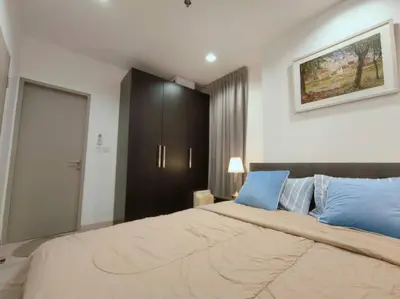 a bedroom with a large bed with blue pillows at Close to onnut bts condo in Bangkok