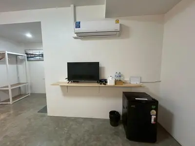a room with a desk with a television and a heater at Choose me guesthouse in Bang Kruai