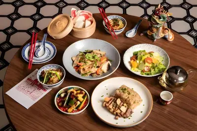 a wooden table with plates of food on it at XX Hidden Dragon ChinaTown MRT Wat Mangkon Station in Samphanthawong