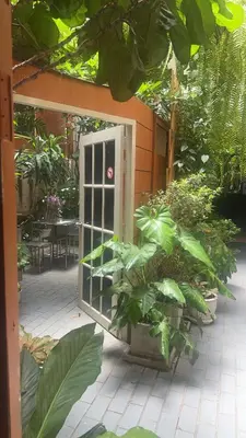 an open door in a garden with plants at Vonden Garden by Merry V in Bangkok