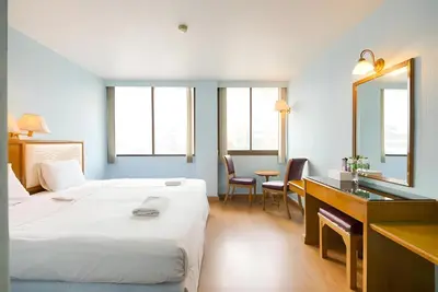 a hotel room with a bed and a desk and a mirror at XX Wish Inn BTS Chidlom - วิช อินน์ บีทีเอส ชิดลม in Pratunam