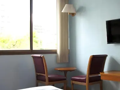 a room with two chairs and a table and a window at XX Wish Inn BTS Chidlom - วิช อินน์ บีทีเอส ชิดลม in Pratunam